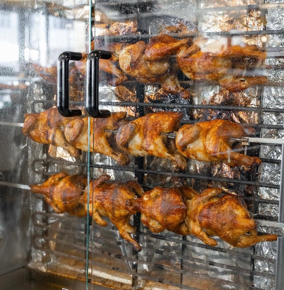Pollos al spiedo girando en el asador de El Gallo Turuleco